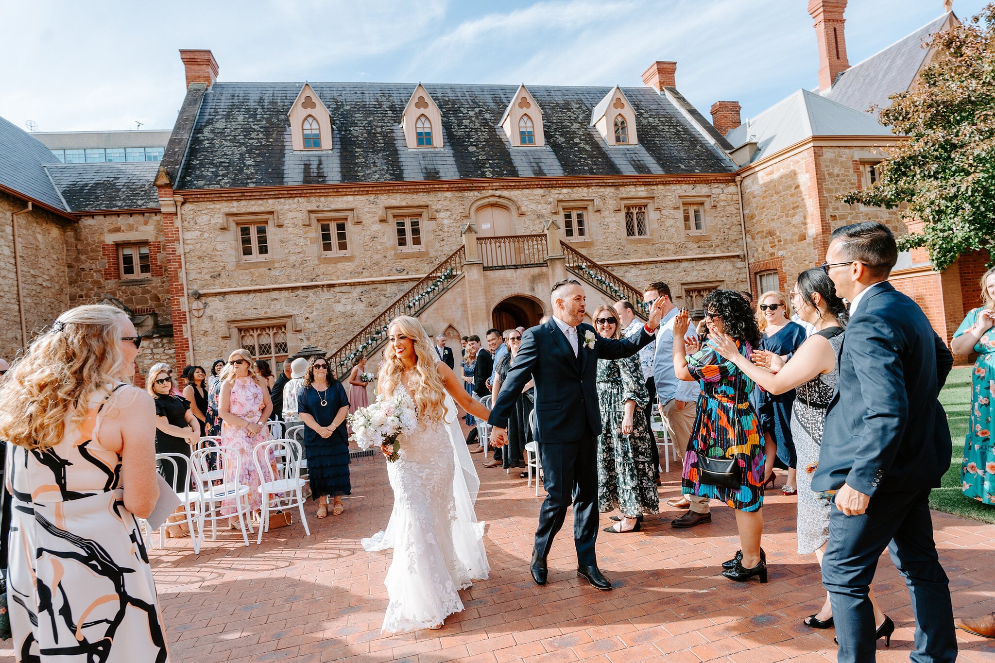Guests reach out to Sarah and Joe as they make their way back up the aisle.