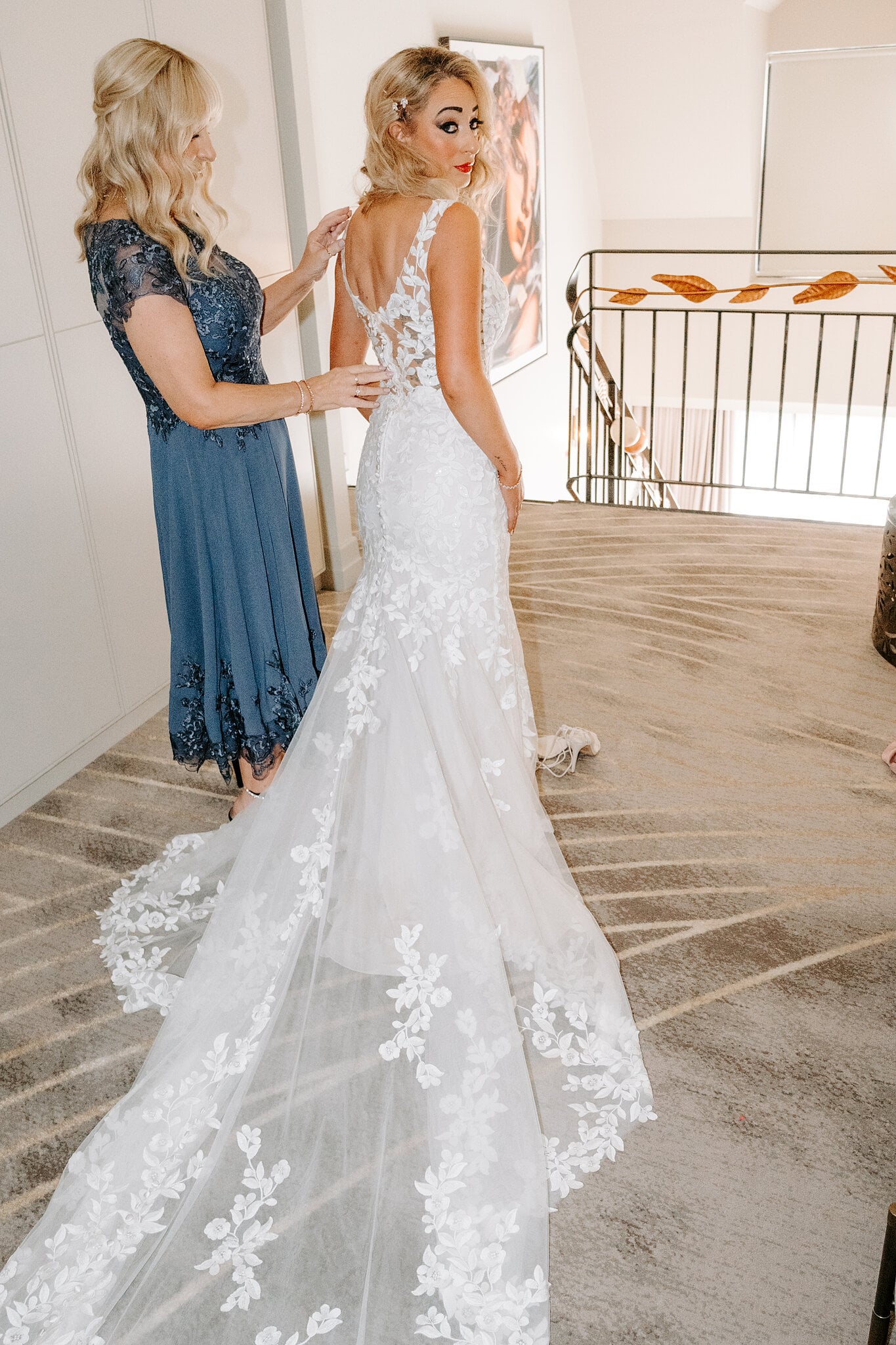 Sarah’s mum fastens the back of her gown, its long lace train spread across the carpet.