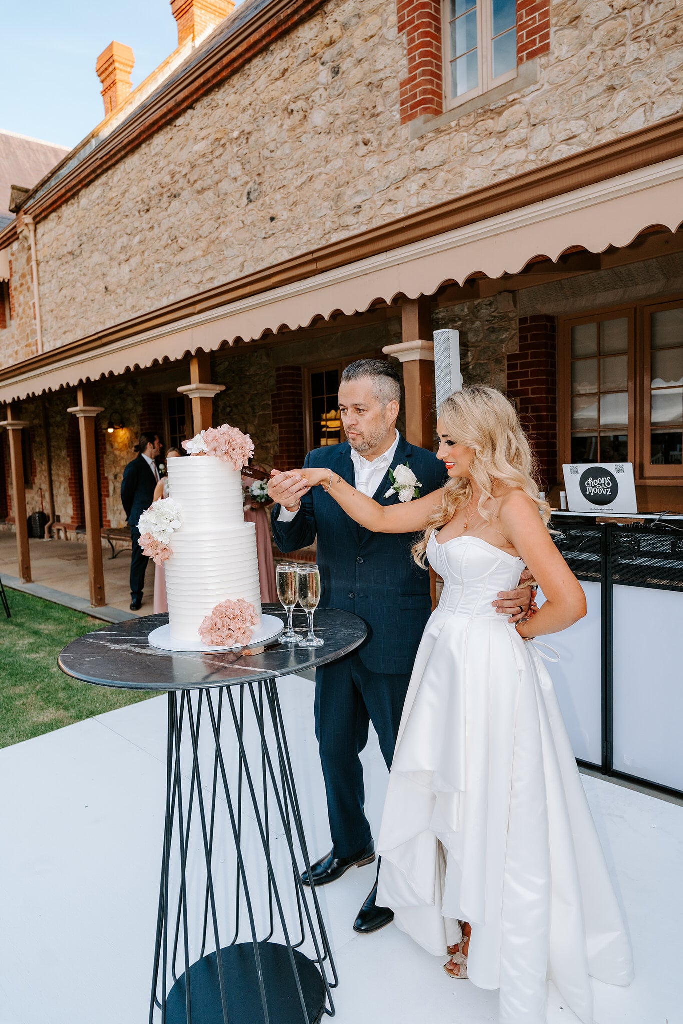 Sarah and Joe cut their wedding cake on the white dance floor under the verandah.