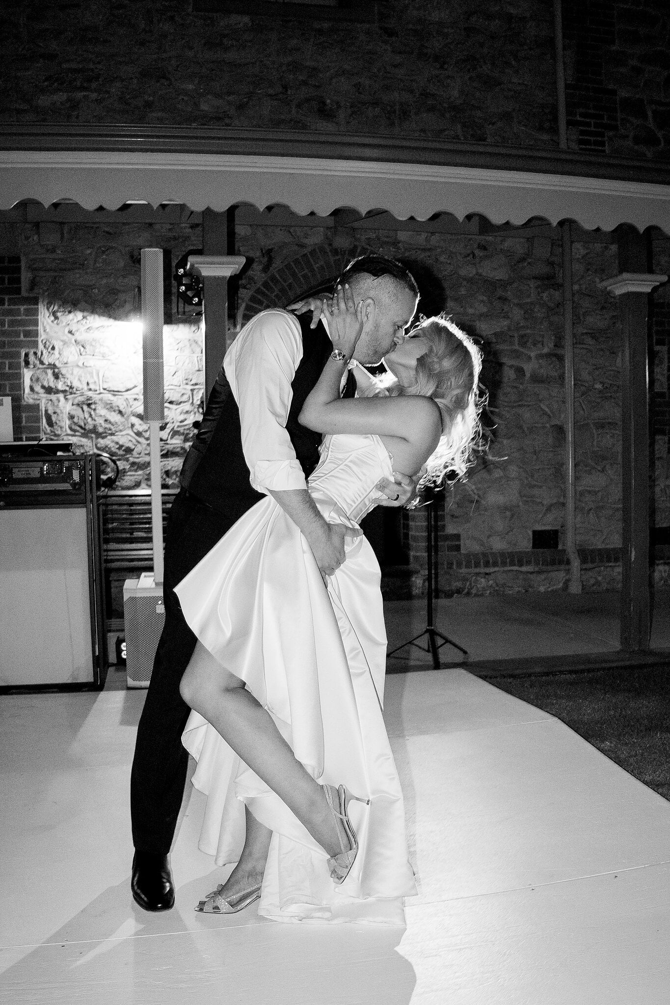 Joe dips Sarah for a kiss on the dance floor, in black and white.
