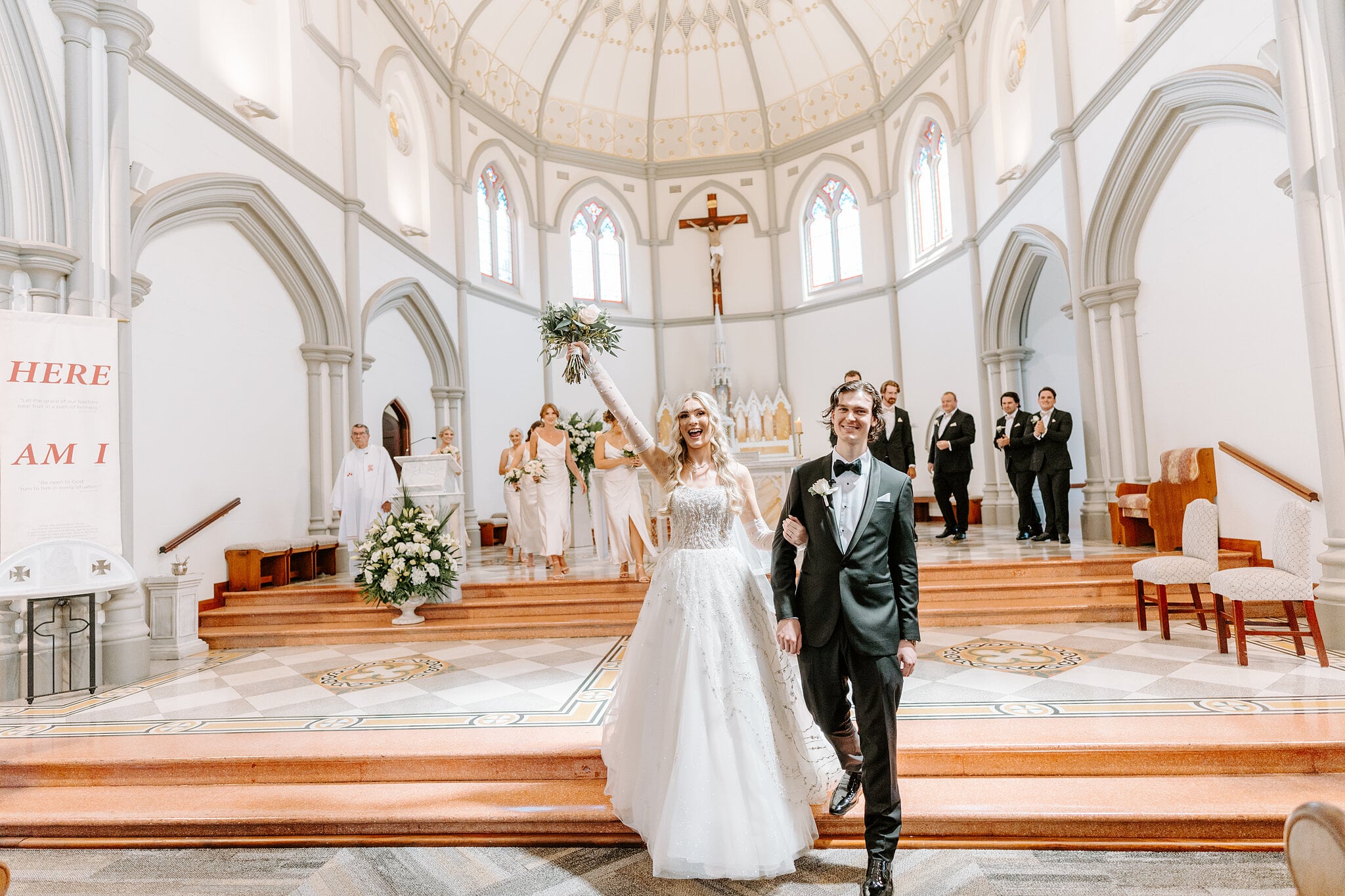 Claire throws her bouquet high as she and George walk back down the aisle at St Joseph’s.