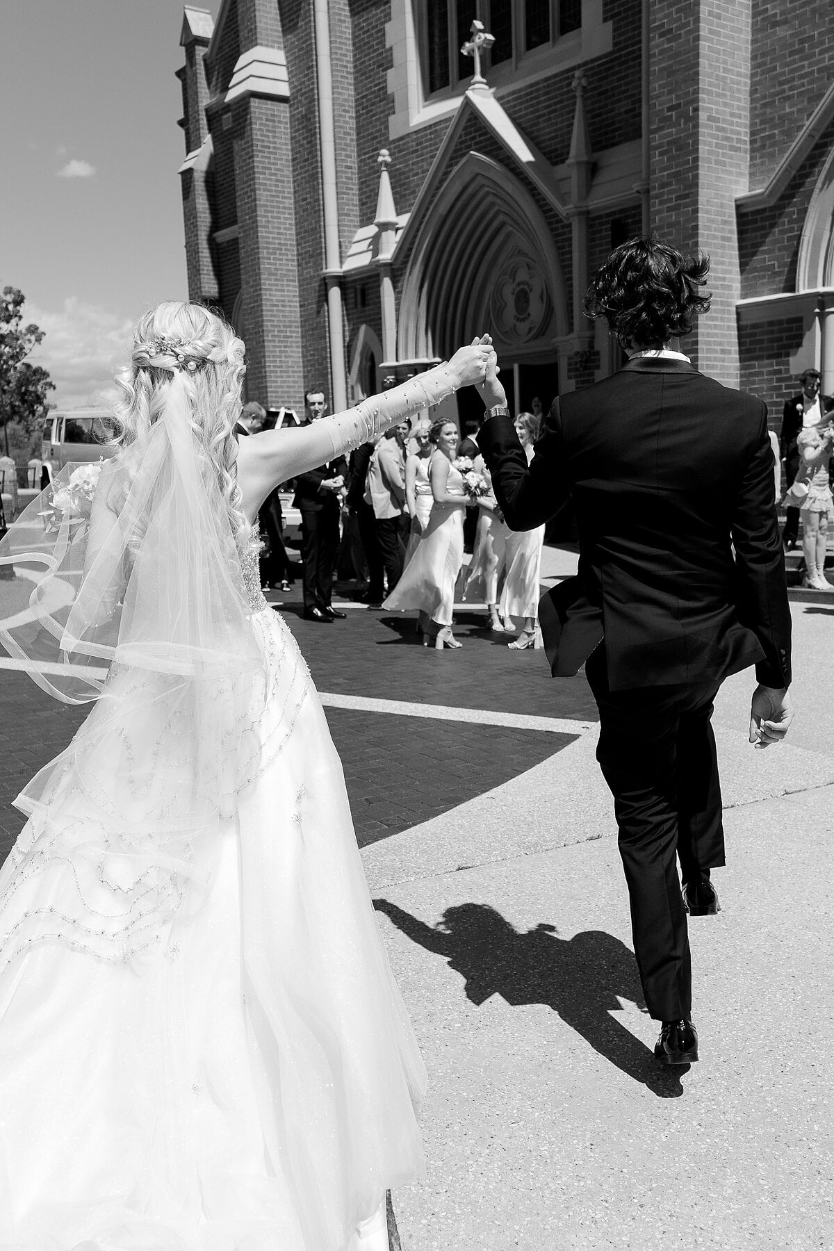 Outside the Gothic brick church, Claire raises George’s hand high as guests cheer.