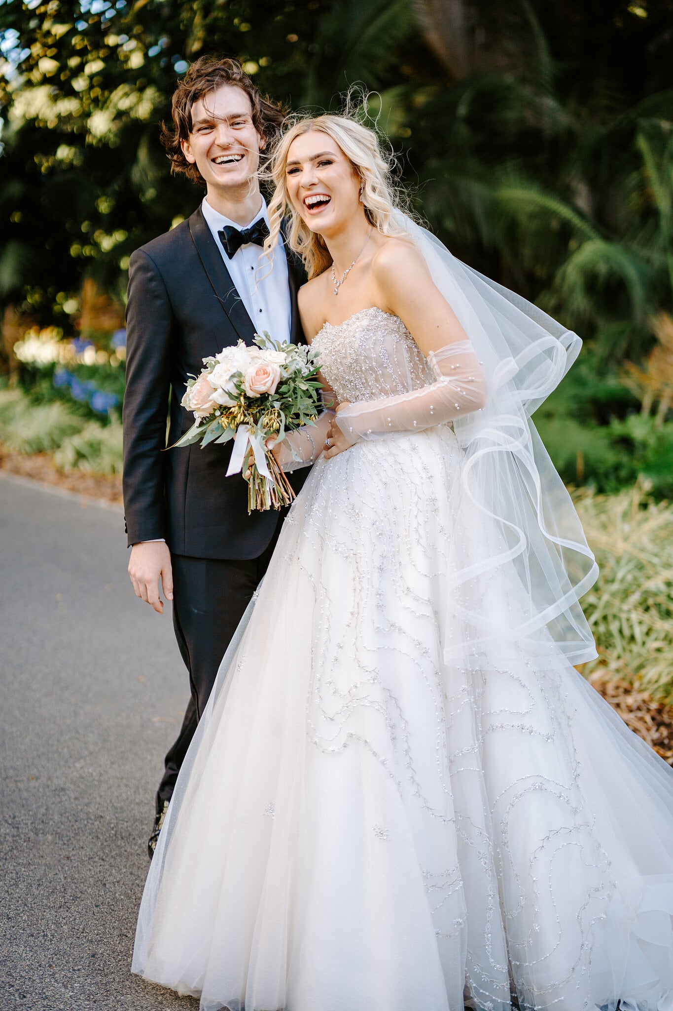 Claire and George burst out laughing on a garden path in the Supreme Court Gardens.