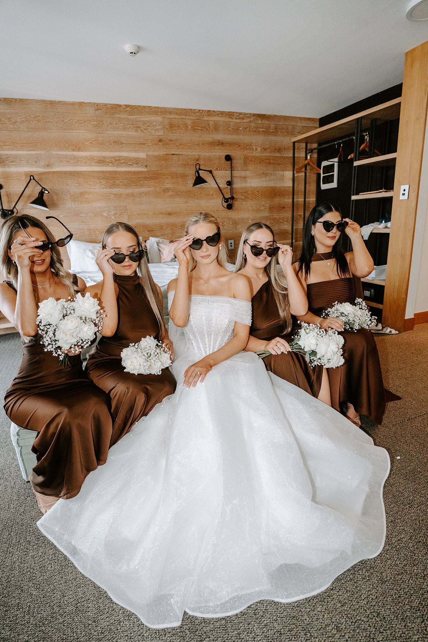 Sorayaa and her bridesmaids in chocolate satin slide on their sunglasses in the suite.