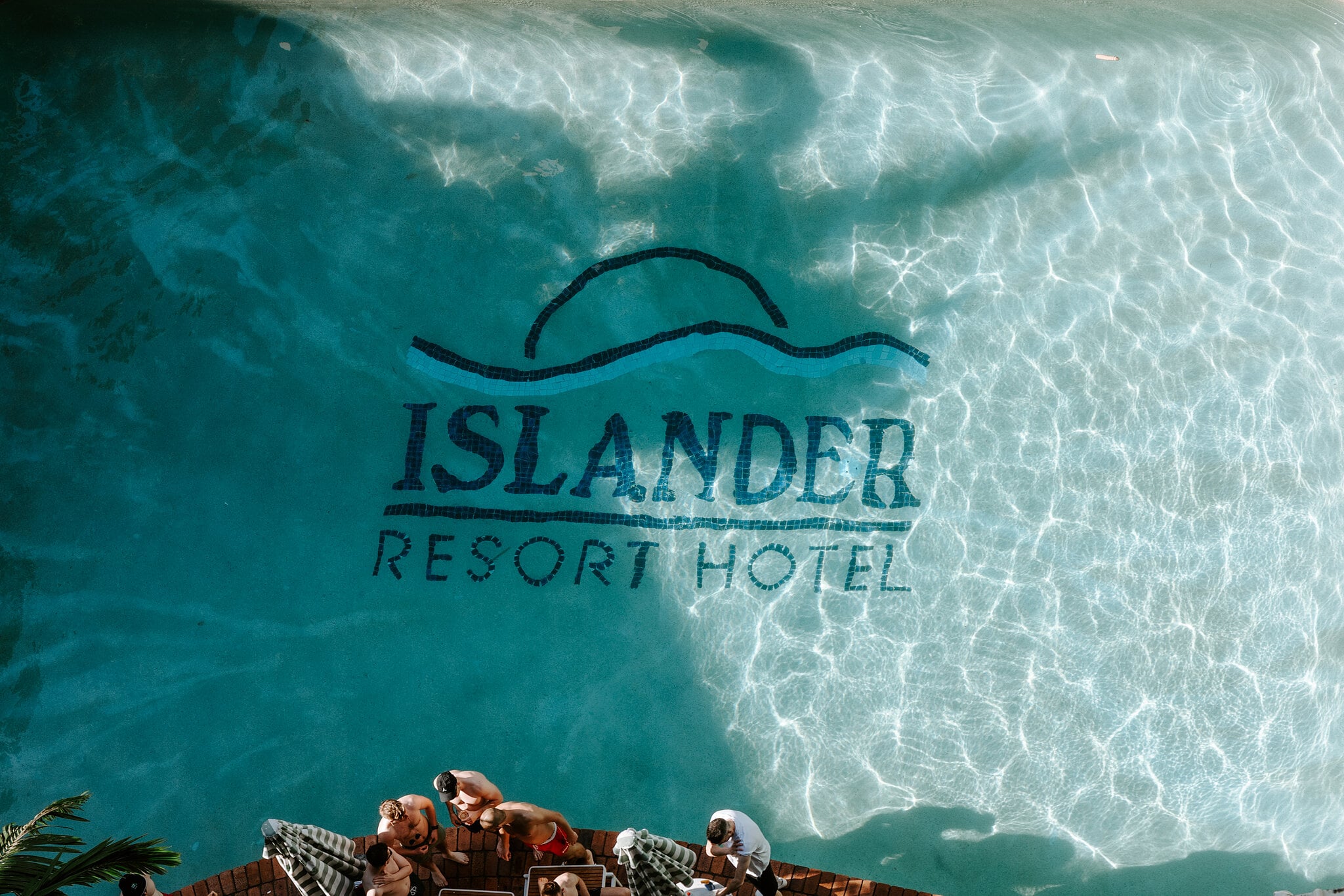 Looking down into the pool at The Island Gold Coast, where the old Islander Resort Hotel logo still shines through the water.