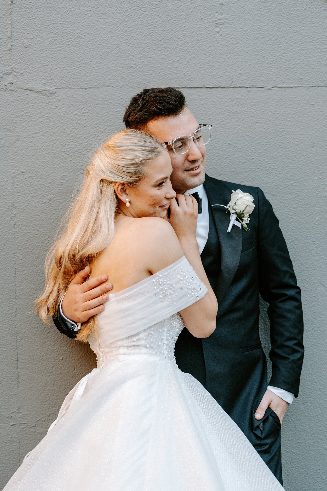 Sorayaa wraps her arms around Jordan, cheek to his shoulder.