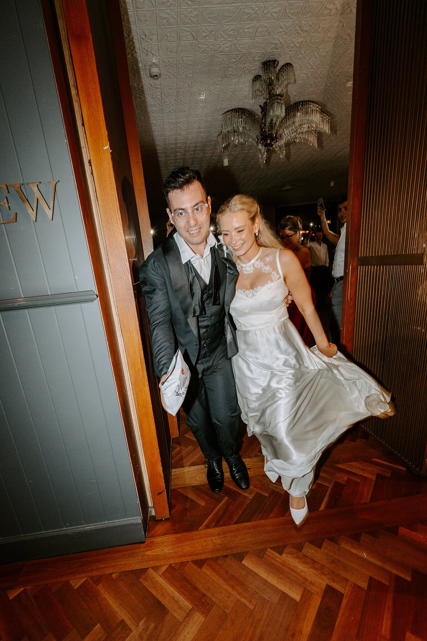 Sorayaa and Jordan burst into their reception at The Penthouse, her satin second dress swishing.