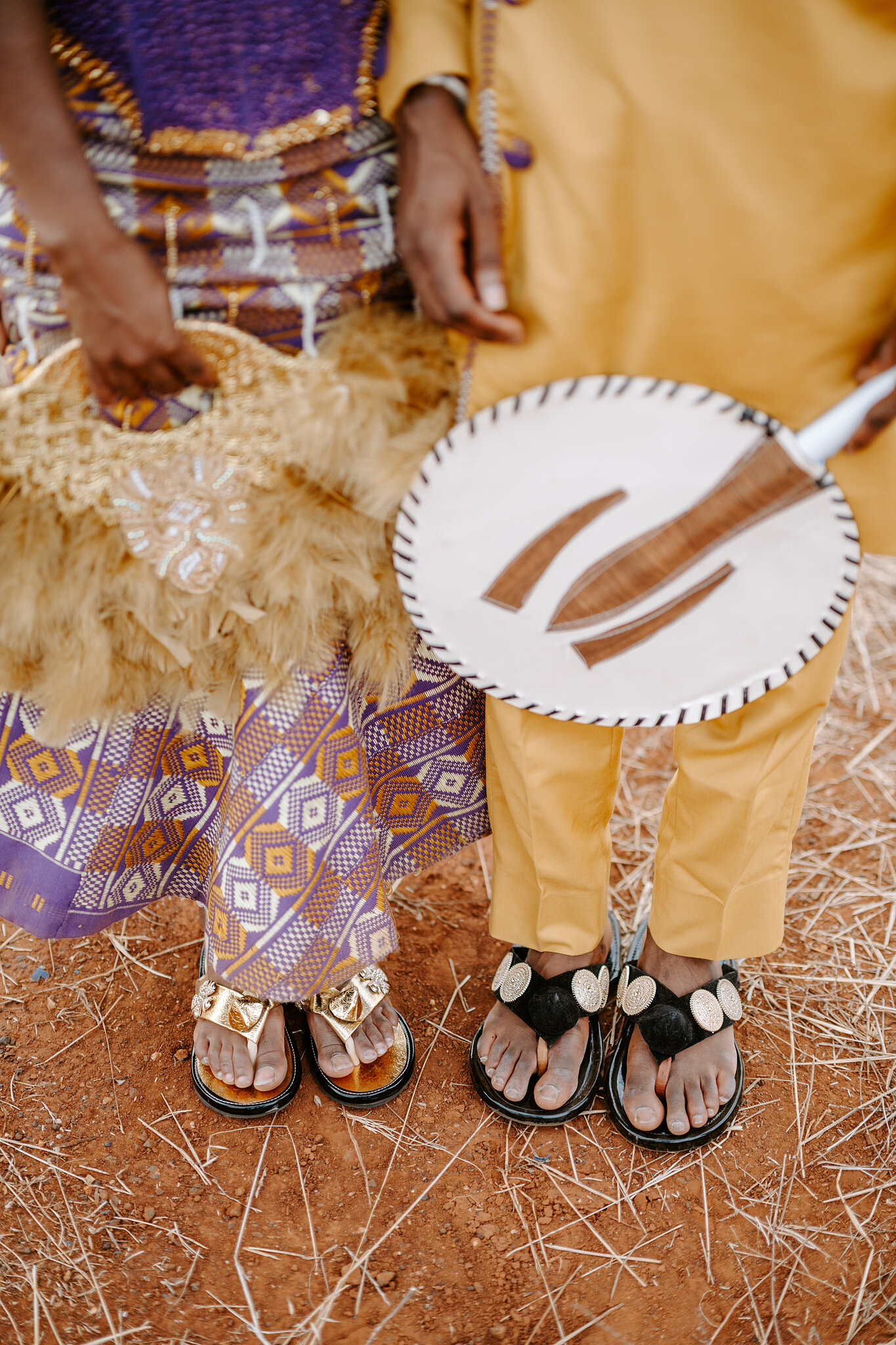 Pearl’s feather fan and Allen’s round painted fan above their gold and black embellished sandals.